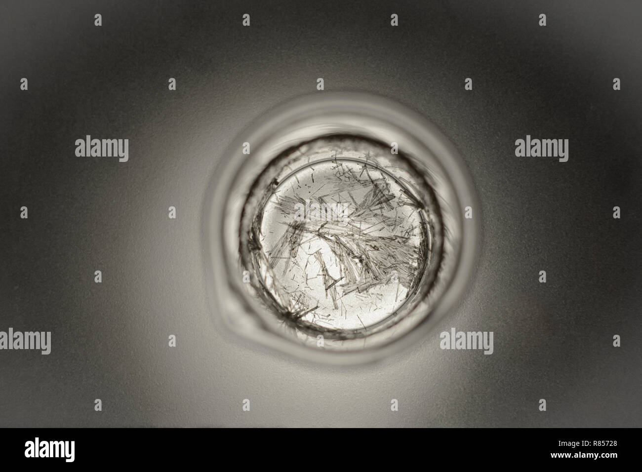 Chemische Glas mit Kristallen der Salicylsäure auf eine Matte Glas mit Hintergrundbeleuchtung von unten Stockfoto