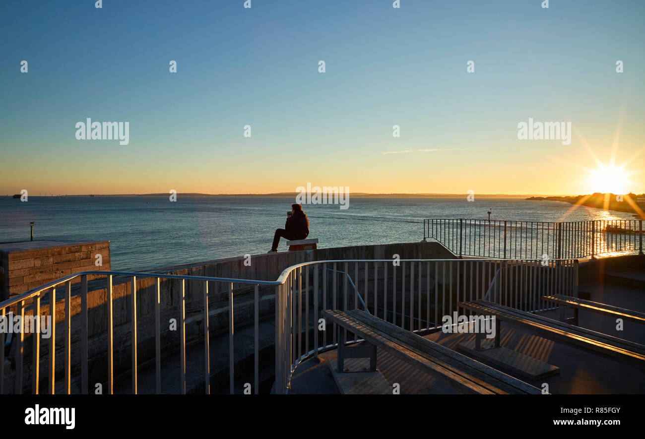 Sonnenuntergang über den Solent gesehen von der Spitze des runden Turms in Portsmouth mit Lone jüngeren Mann Stockfoto