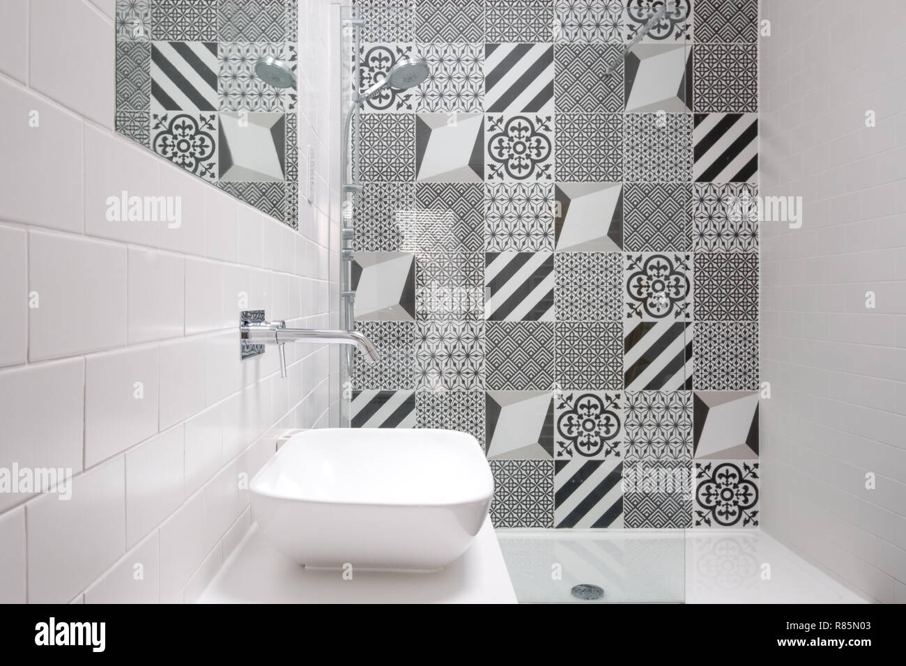 Moderne loft Bad mit ebenerdiger Dusche und Schwarze und Weiße monochrome Porzellan Wandfliesen. Stockfoto