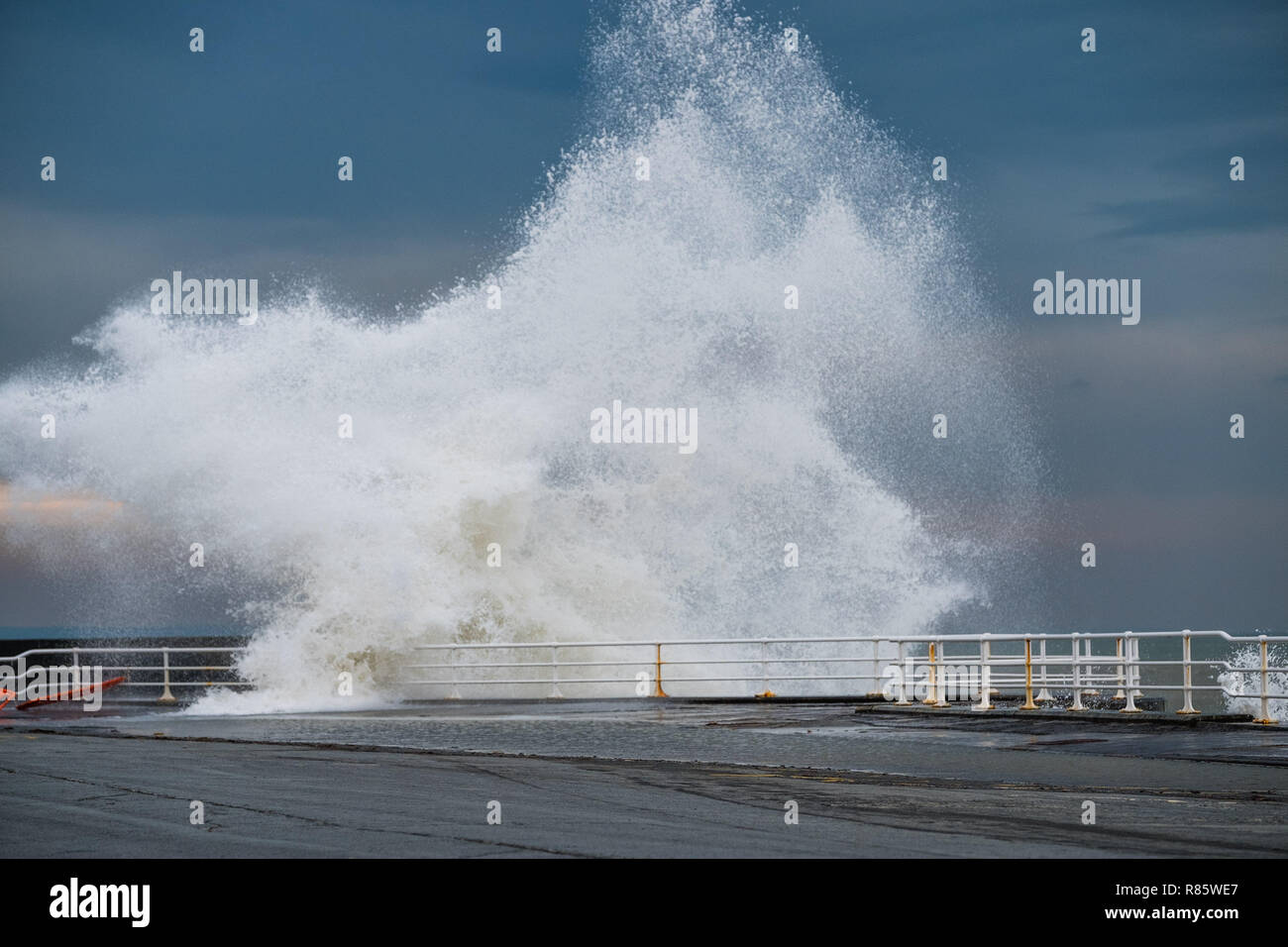 Aberystwyth, Wales. 13. Dez 2018. UK Wetter: Strong gale force Winden und eine Flut kombinieren riesige Wellen gegen das Meer Abwehr in Aberystwyth auf der Cardigan Bay Küste von West Wales zu hämmern. Ein bitter kalt easterly Wind mit Böen bis 36 km/h und eine Frost ist über Nacht, da der Himmel klar Foto Keith Morris/Alamy Leben Nachrichten Prognose Stockfoto
