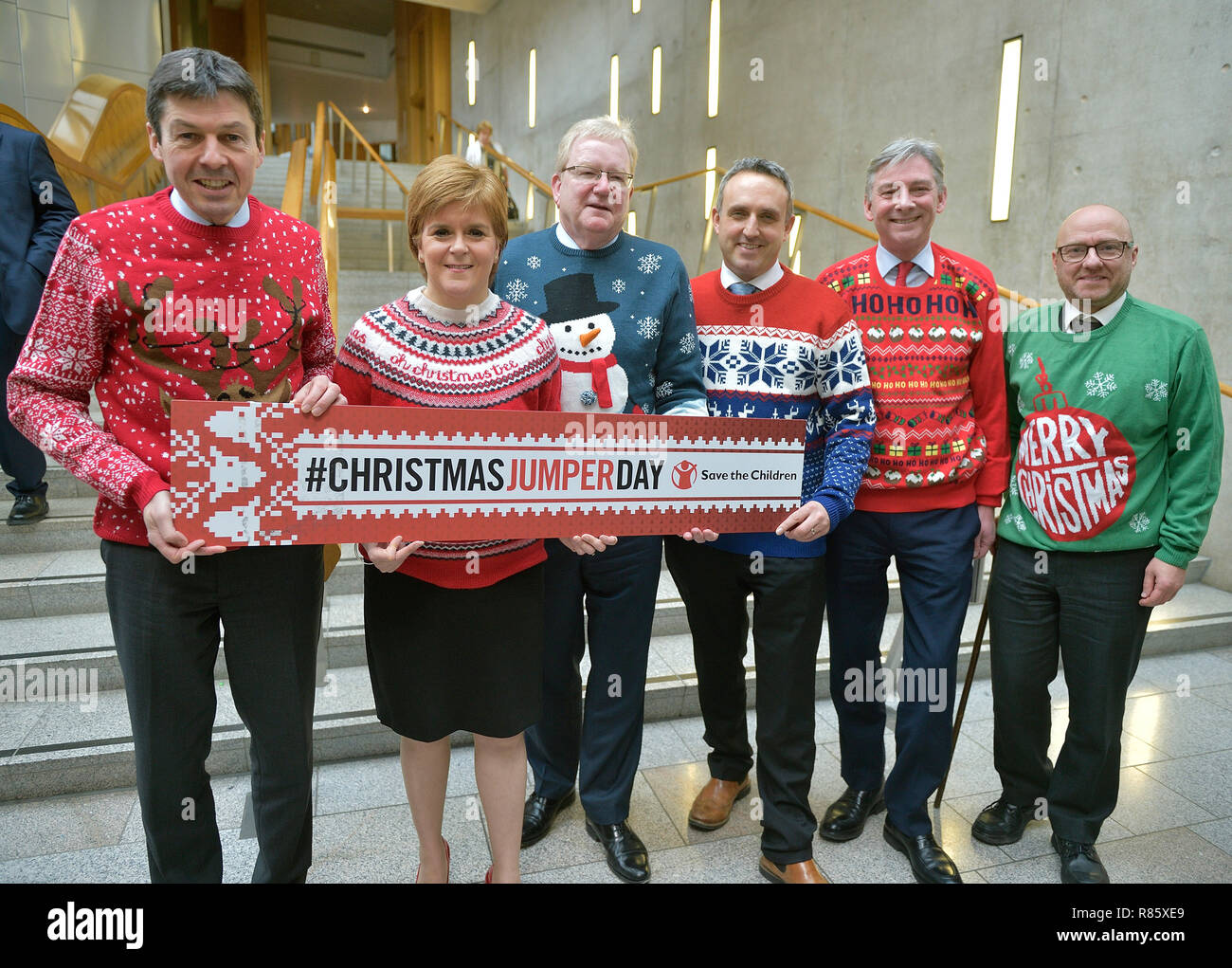 Speichern der Kinder Weihnachten Jumper Tag 2018. Bild L-R an das Schottische Parlament mit ihrem Weihnachten Jumper sind Ken Macintosh msp, Vorsitzende des Schottischen Parlaments, Erster Minister Nicola Sturgeon (SNP), Jackson Carlaw Schottischen Konservativen stellvertretender Fraktionsvorsitzender, Alex Cole Hamilton MSP, Liberaldemokratischen, Richard Leonard leader Scottish Labour Party und Patrick Harvie co-Convenor der schottischen Grünen Partei. Stockfoto