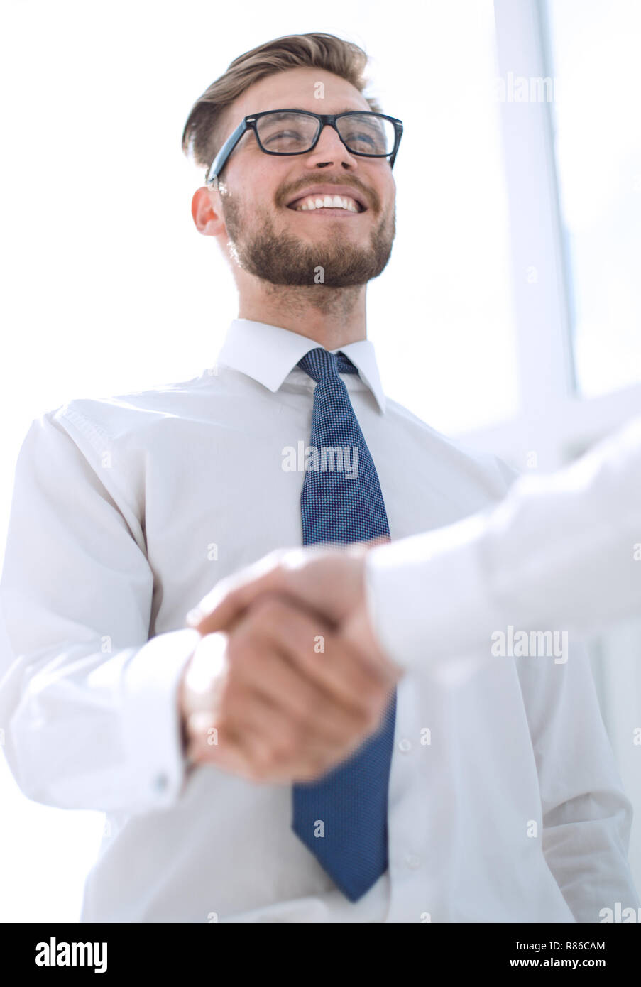 Aus der Nähe. Ein Lächeln Mitarbeiter Schütteln der Hand seines Kollegen Stockfoto