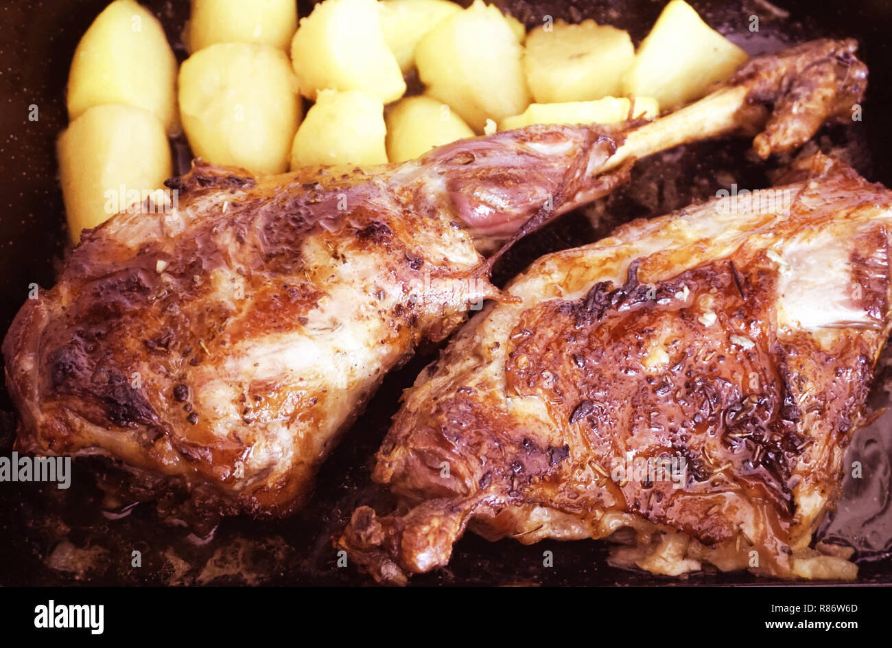 Gebratenes Lamm Bein mit mediterranen Gewürzen und gebackene Kartoffeln in der Pfanne. Organische Lamm treffen aus dem Kroatischen Insel Pag Stockfoto