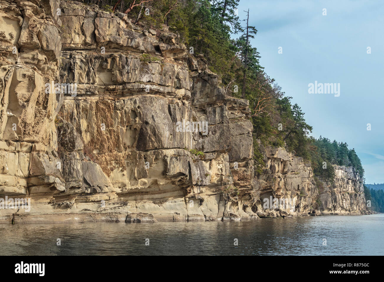 Entlang der Küstenlinie Valdes's Island, steil, erodiert Sandsteinfelsen komplizierte Strukturen und Mustern, mit dem Wald über Ihnen (British Columbia). Stockfoto