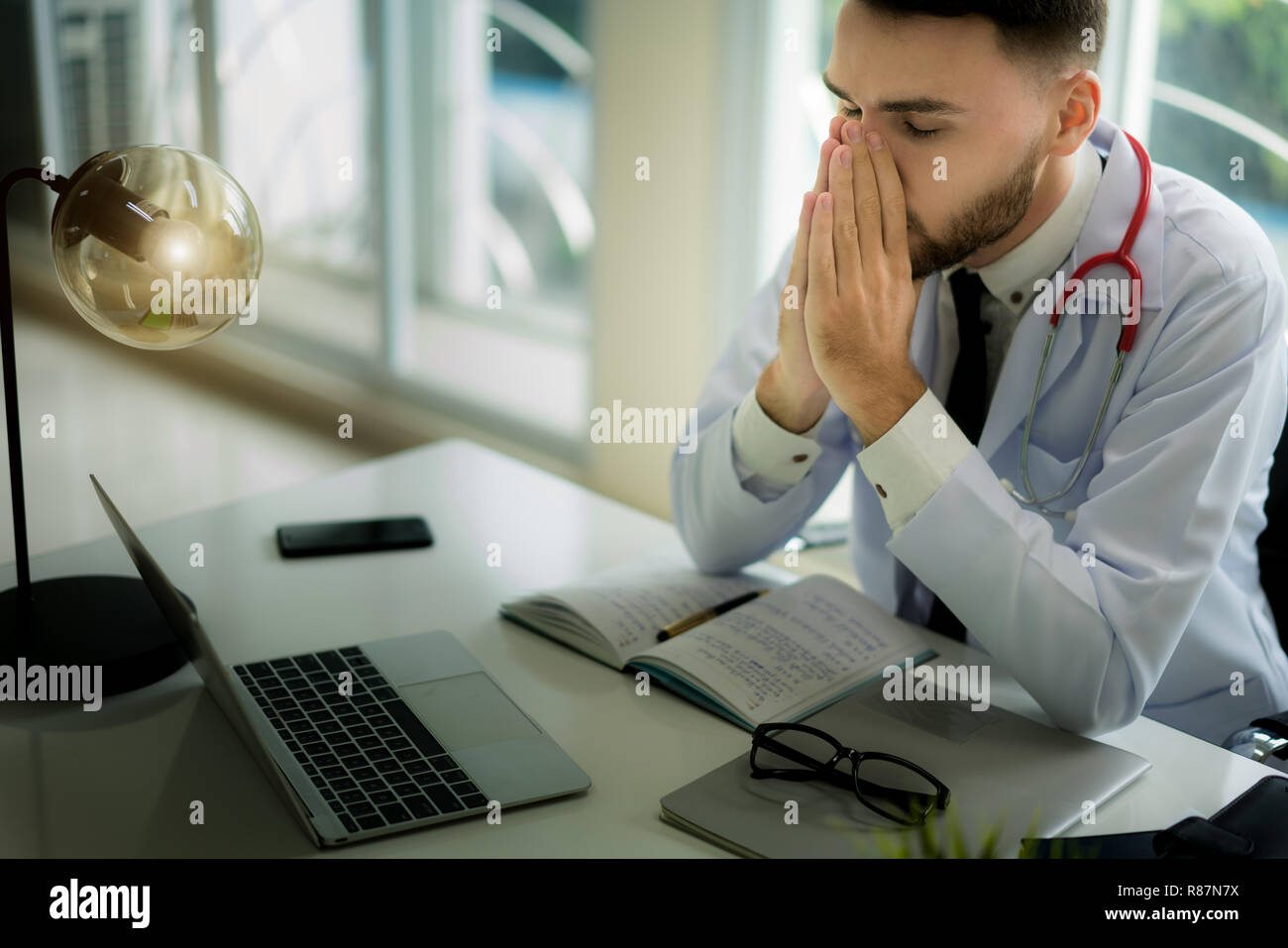 Ärzte sind die ernsten Gesichter und gestresst von der Arbeit. Der Arzt ist ein Gefühl der Kopfschmerzen bei der Arbeit und das Gefühl, in der Behandlung des Patienten betont. Stockfoto