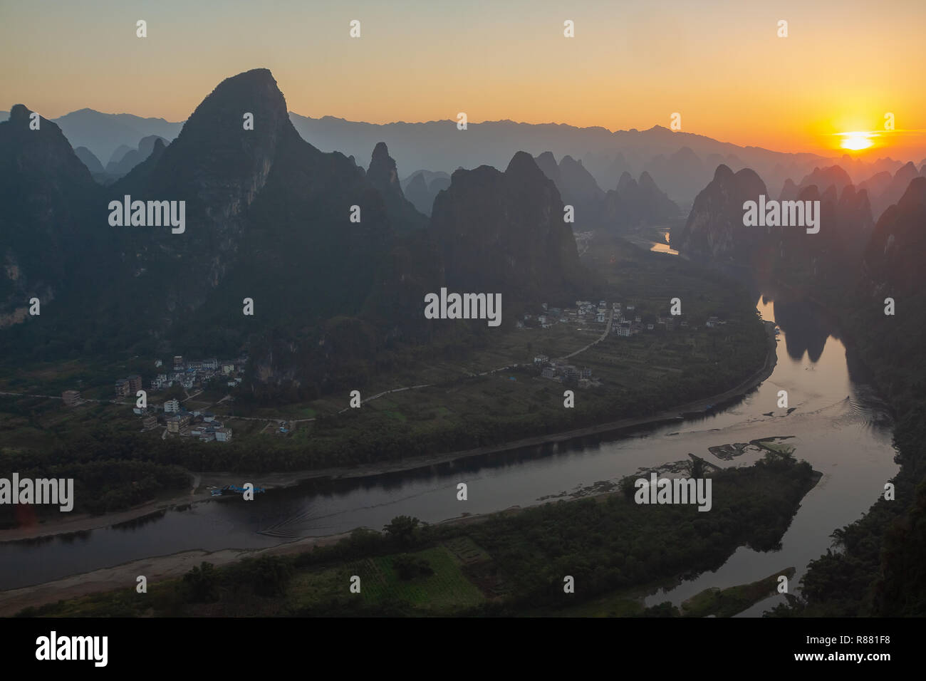 Sonnenaufgang über dem Fluss Li Ab Xianggong Berg, Guilin, Yangshuo, China gesehen. Landschaft ist in Silhouette mit orange Sonne auf der oberen, rechten. Stockfoto