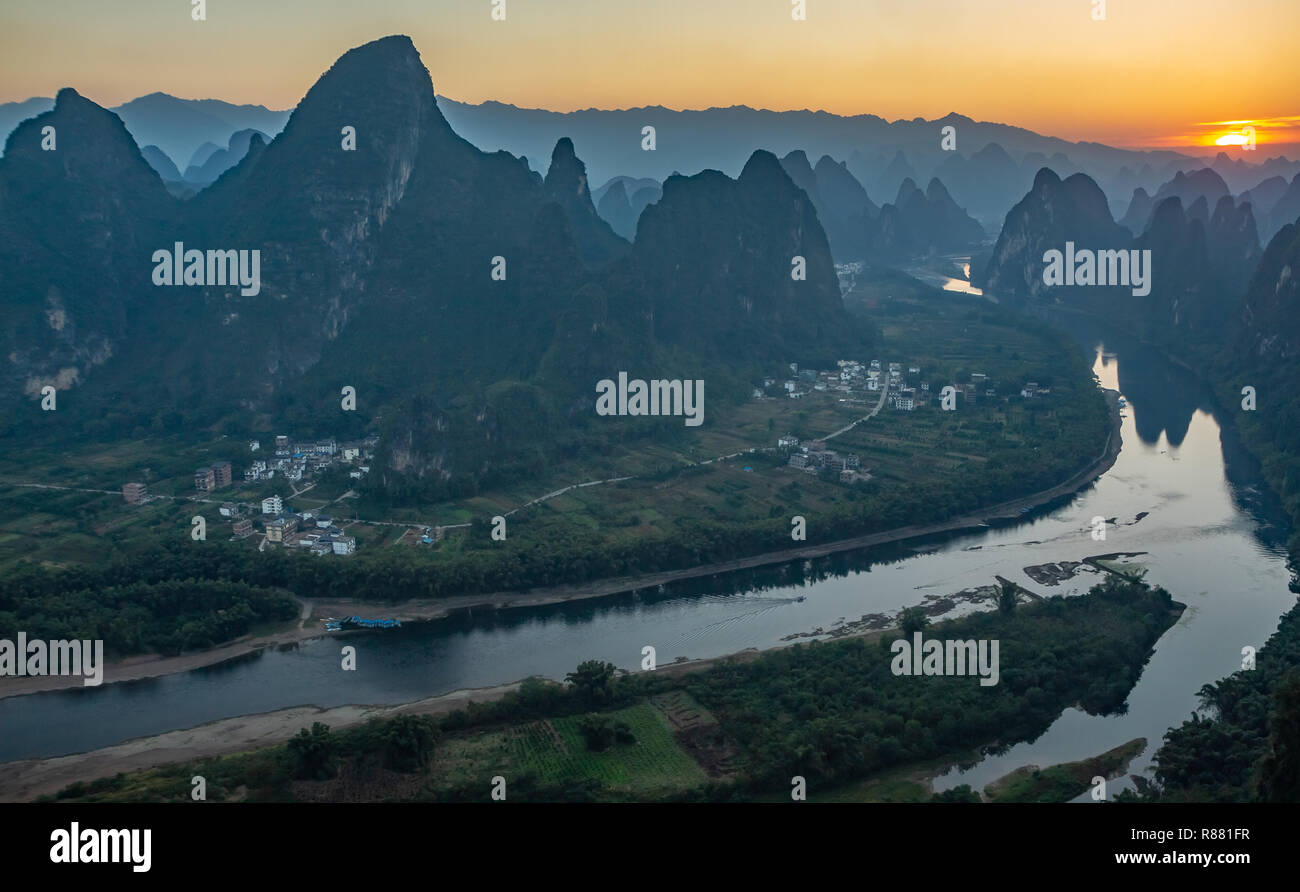 Sonnenaufgang über dem Fluss Li Ab Xianggong Berg, Guilin, Yangshuo, China gesehen. Landschaft ist in Silhouette mit orange Sonne auf der oberen, rechten. Stockfoto