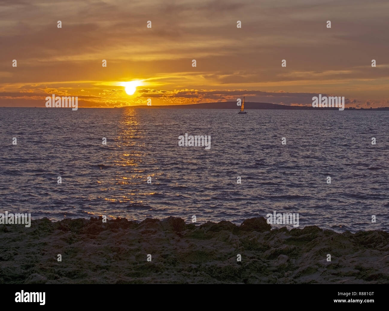 Meereslandschaft mit Segelboot über Sonnenuntergang im Mittelmeer auf Mallorca, Spanien. Stockfoto