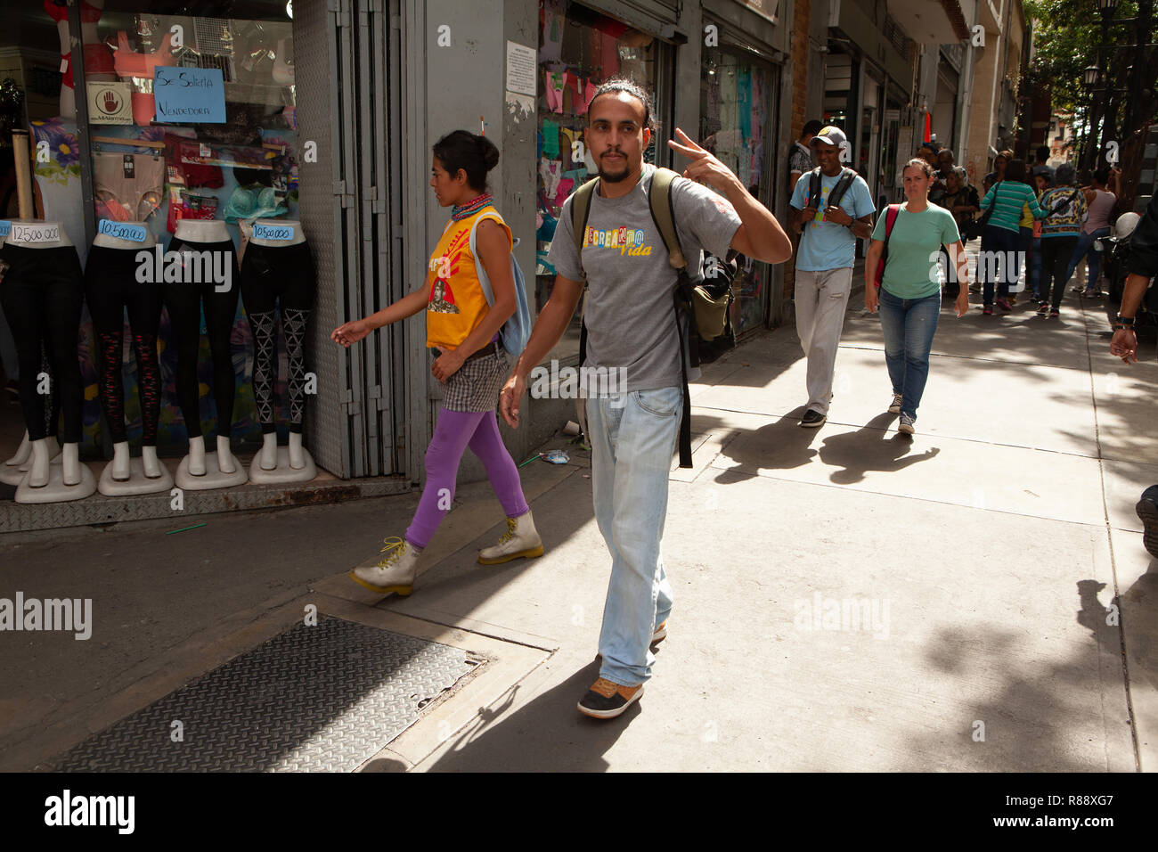 Mann zu Fuß entlang der Straße zwei Finger Geste, Caracas, Venezuela, Südamerika Stockfoto
