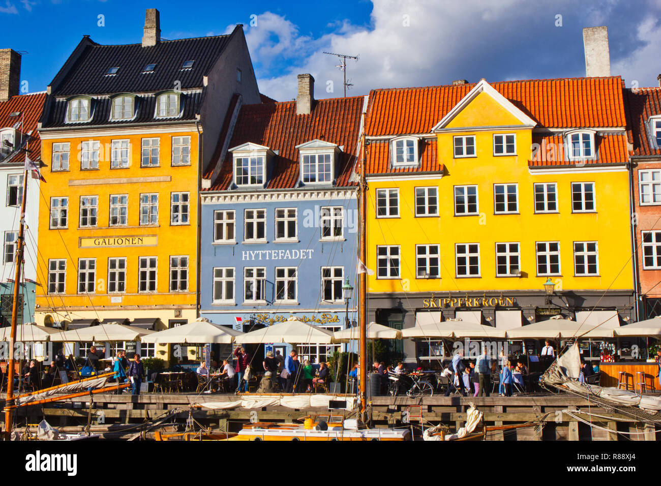 Alfresco am Kanal gelegenes Tischen und Stühlen und hell gestrichenen Reihenhäuser, Nyhavn, Kopenhagen, Dänemark, Skandinavien Stockfoto