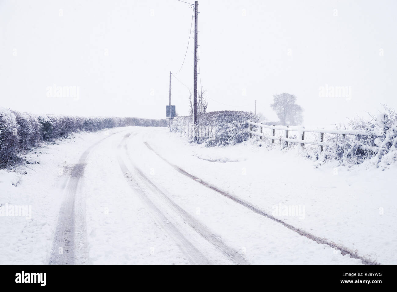 Winterliche Szene von Lane von Hatton Bank Hampton Lucy in Warwickshire, Großbritannien in einem Blizzard und mit Schnee bedeckt. Stockfoto