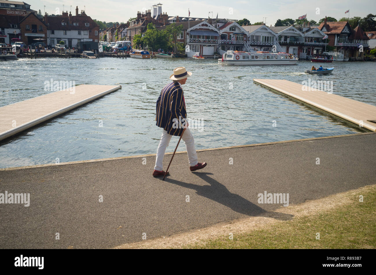 Ein Mann im gestreiften rudern Blazer und Panama Hut Spaziergänge auf dem leinpfad am Henley Royal Regatta, Henley-on-Thames. Oxfordshire Stockfoto