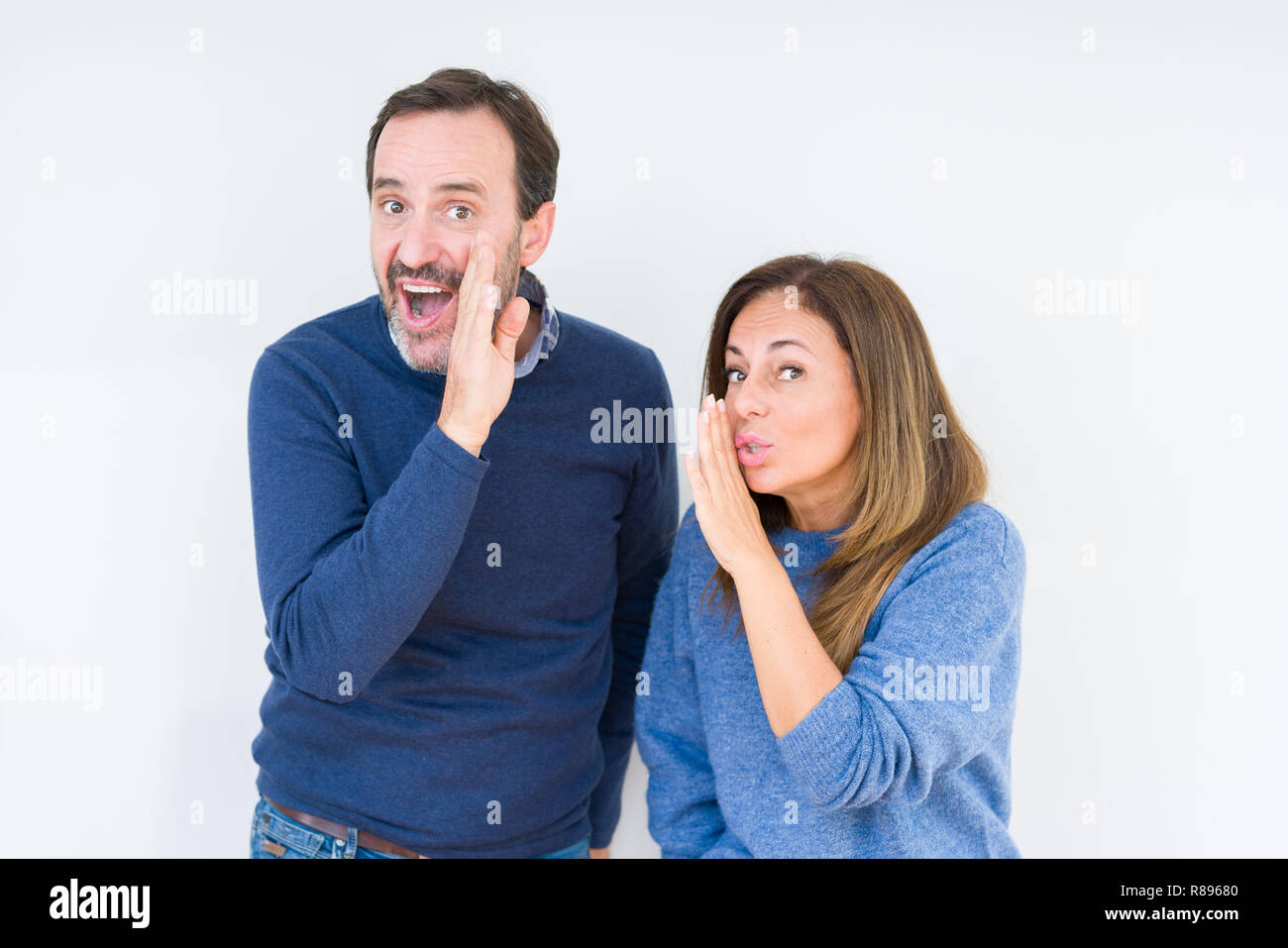 Schönen mittleren Alter Paar in Liebe über isolierte Hintergrund hand auf Mund, geheime Gerücht, Flüstern bösartige talk Gespräch Stockfoto