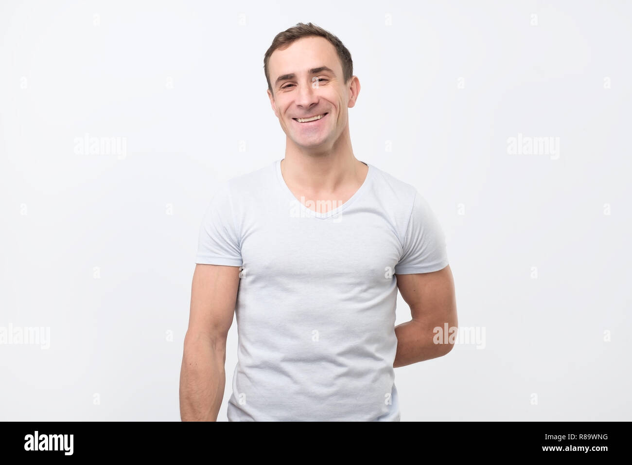 Urlaub und besondere Anlässe. Junger Mann hinter seinem Rücken versteckt Geschenk für seine Freundin. Stockfoto