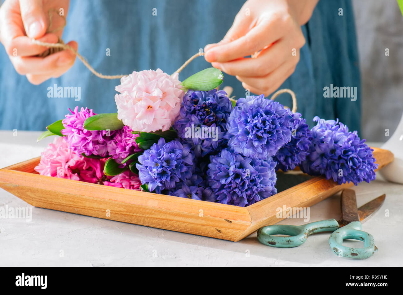 Frau tieing Blumenstrauß aus Hyazinthen Blumen. Life style Foto. Kopieren Sie Platz. Im skandinavischen Stil. Stockfoto