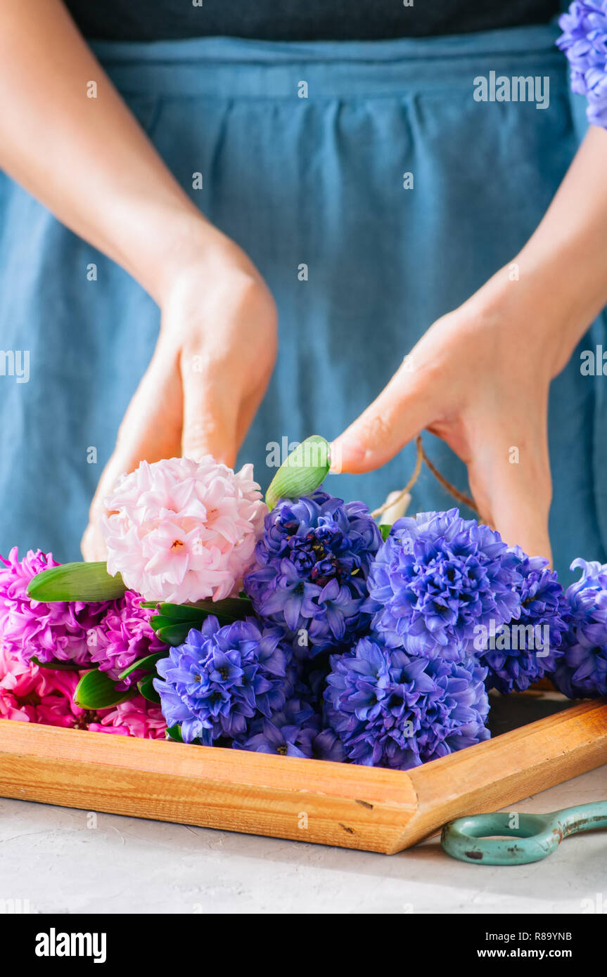 Frau tieing Blumenstrauß aus Hyazinthen Blumen. Life style Foto. Kopieren Sie Platz. Im skandinavischen Stil. Stockfoto