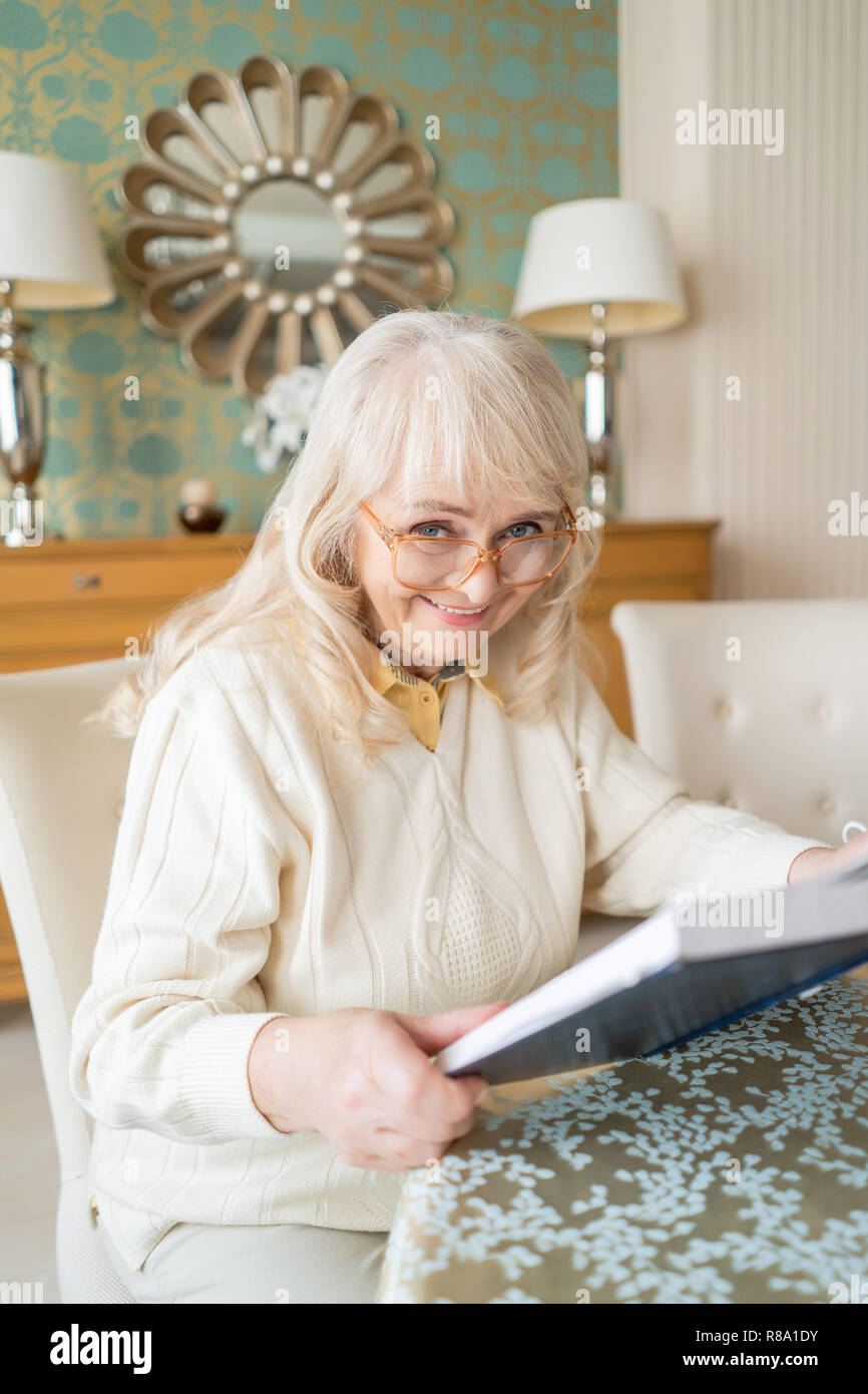 Portrait auf einem wunderschönen alten Dame in Gläser, ein Buch zu lesen. Elegantes Haus und Großmutter in Gläser. Stockfoto