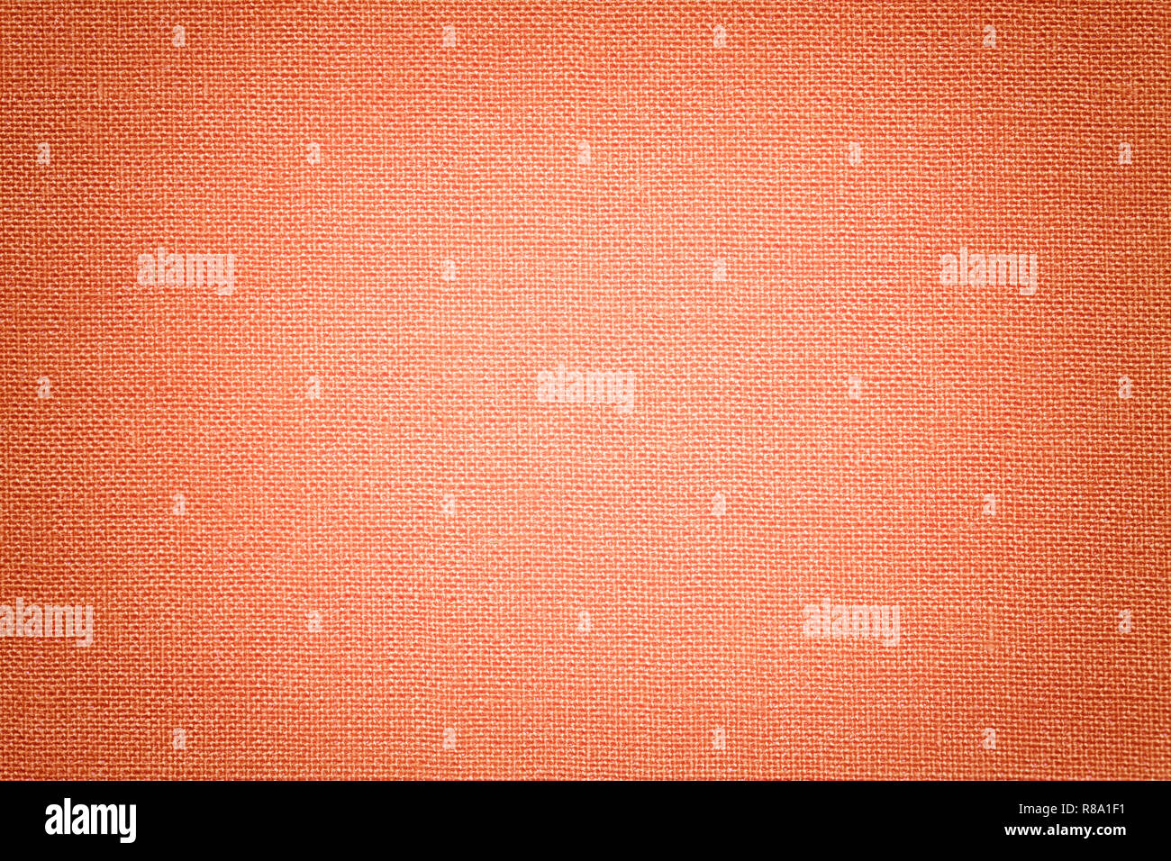 Licht coral Hintergrund aus einem Textilmaterial mit Korbmöbeln Muster, Nahaufnahme. Struktur der orange Stoff mit Textur. Tuch Kulisse mit Vignette Stockfoto