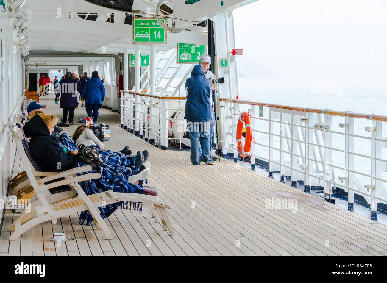 Die Passagiere genießen Sie auf der Terrasse bei kaltem Wetter Kreuzfahrt Urlaub. Rentner genießen unbeschwert reisen Lifestyle auf Kreuzfahrtschiff. Stockfoto