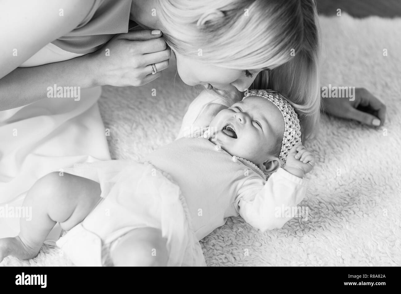 Junge schöne Mutter mit ihrem Baby zu spielen. Mutterschaft-Konzept, Liebe und Fürsorge. Stockfoto
