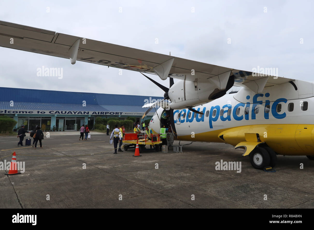 Gepäckabfertiger entladen Gepäck aus einem Cebu Pacific ATR 72-500 Flugzeug  der philippinischen Billigfluggesellschaft im Cauayan Airport, das das  allgemeine Gebiet von Cauayan, einer Stadt in der Provinz Isabela auf den  Philippinen, bedient