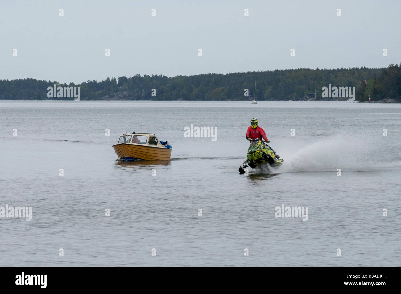 Freizeit Boot und ein Schneemobil auf Wasser, Norrtälje, Schweden konkurrieren. Stockfoto