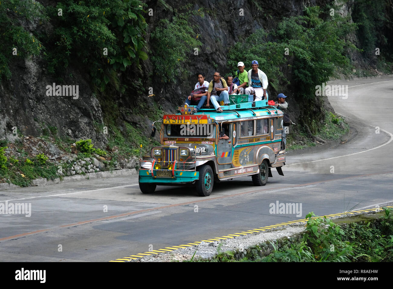 Voll gepackt mit einem Jeepney, Fahrten entlang einer gekrümmten bergigen Straße in Isabela Provinz in den Philippinen Stockfoto