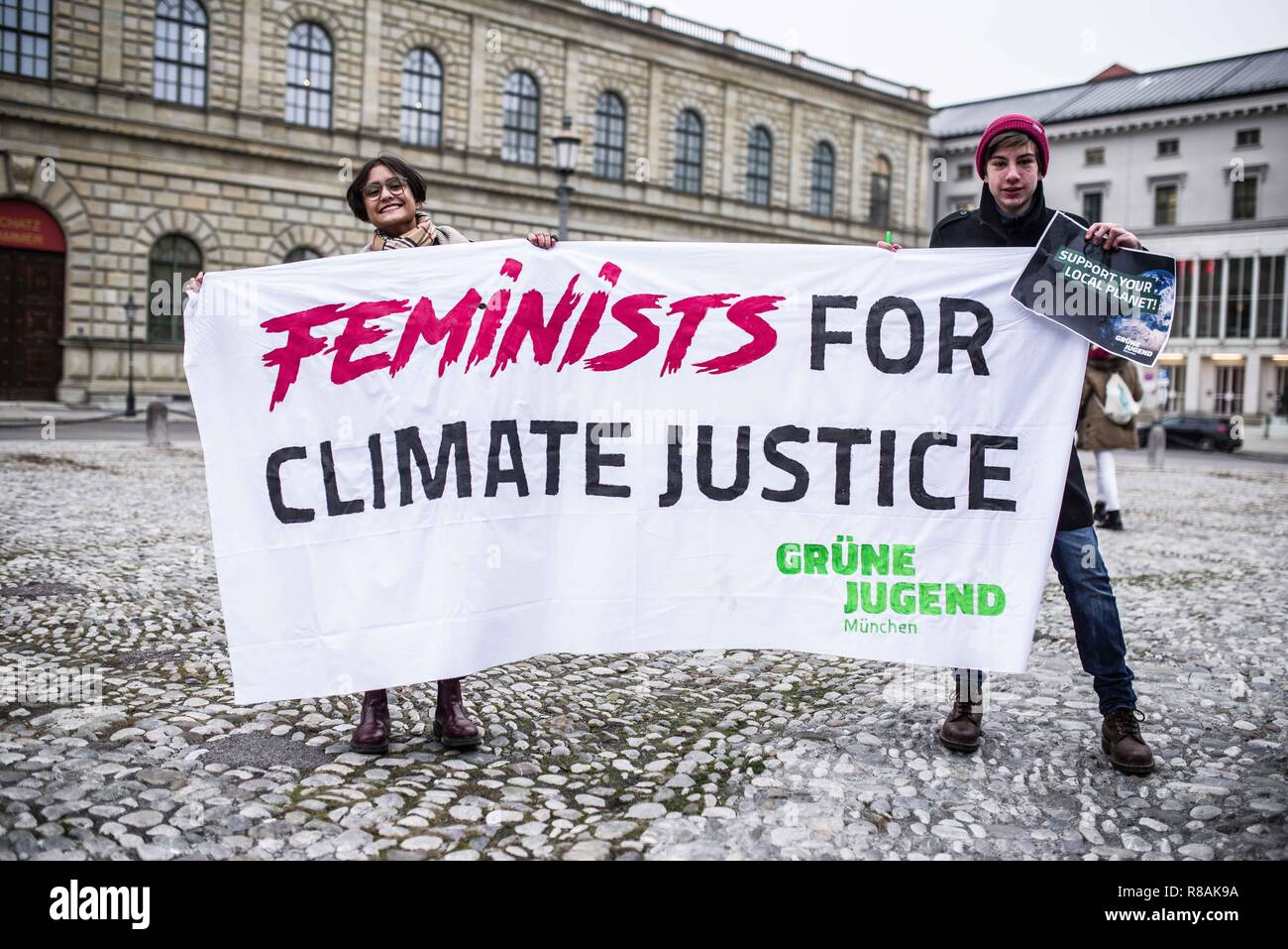 München, Bayern, Deutschland. 14 Dez, 2018. Als Teil einer weltweiten Aktion, 100 Studenten und der betroffenen Bürger in einem Klima Streik am Münchner Max Joseph Platz teilgenommen. Die Demonstranten fordern die Regierungen der Welt entschiedene Maßnahmen gegen den Klimawandel zu ergreifen. Die Demonstration endete mit einer künstlerischen Aktion, wo die Teilnehmer Chalk verwendet den Boden mit ökologischen Designs und Slogans. Einer der Entwürfe war ein durchgestrichenes Hakenkreuz, was bedeutet, dass die Haltung der Gruppe gegen Nazis, die die Polizei behauptet wurde als solche nicht wahrnehmbar und der Veranstalter eine crimi empfangen Stockfoto