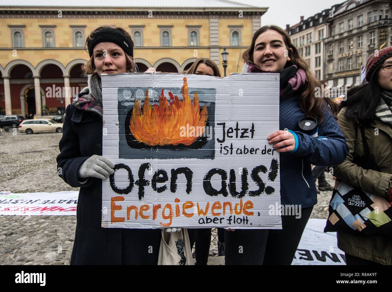 München, Bayern, Deutschland. 14 Dez, 2018. Als Teil einer weltweiten Aktion, 100 Studenten und der betroffenen Bürger in einem Klima Streik am Münchner Max Joseph Platz teilgenommen. Die Demonstranten fordern die Regierungen der Welt entschiedene Maßnahmen gegen den Klimawandel zu ergreifen. Die Demonstration endete mit einer künstlerischen Aktion, wo die Teilnehmer Chalk verwendet den Boden mit ökologischen Designs und Slogans. Einer der Entwürfe war ein durchgestrichenes Hakenkreuz, was bedeutet, dass die Haltung der Gruppe gegen Nazis, die die Polizei behauptet wurde als solche nicht wahrnehmbar und der Veranstalter eine crimi empfangen Stockfoto