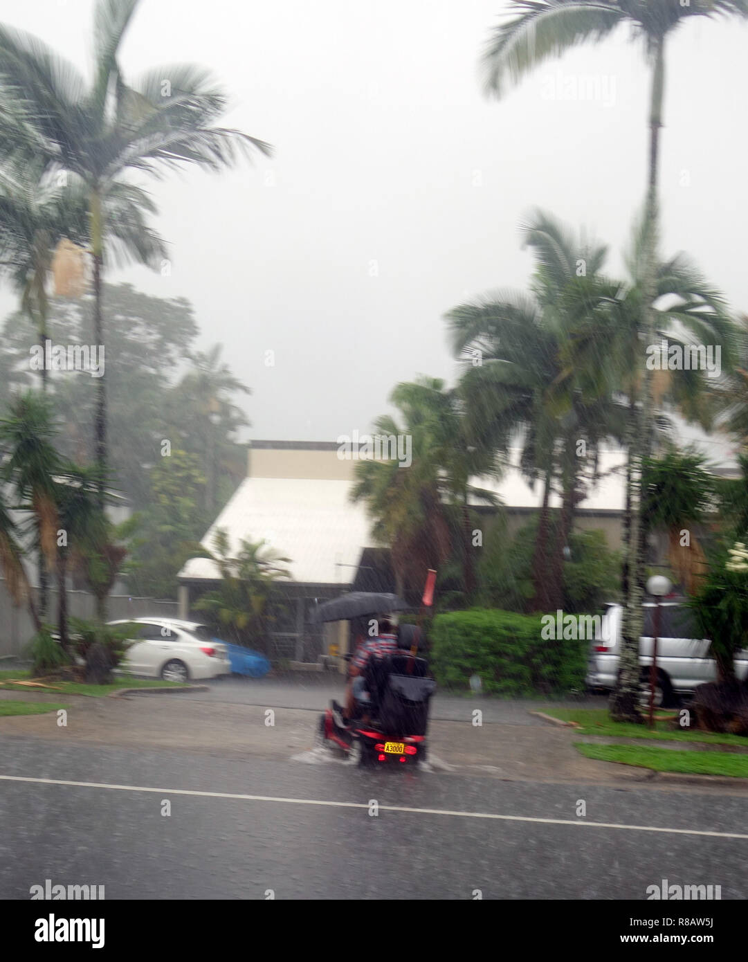 Cairns, Australien, 15. Dez 2018. Erste Stürme aus tropischen Zyklon Owen haben lokalisierte Überschwemmung in Far North Queensland verursacht. Mann auf Mobilität scooter fährt durch Hochwasser im Vorort Edge Hill, Cairns, Queensland, Australien. Credit: Suzanne Long/Alamy leben Nachrichten Stockfoto