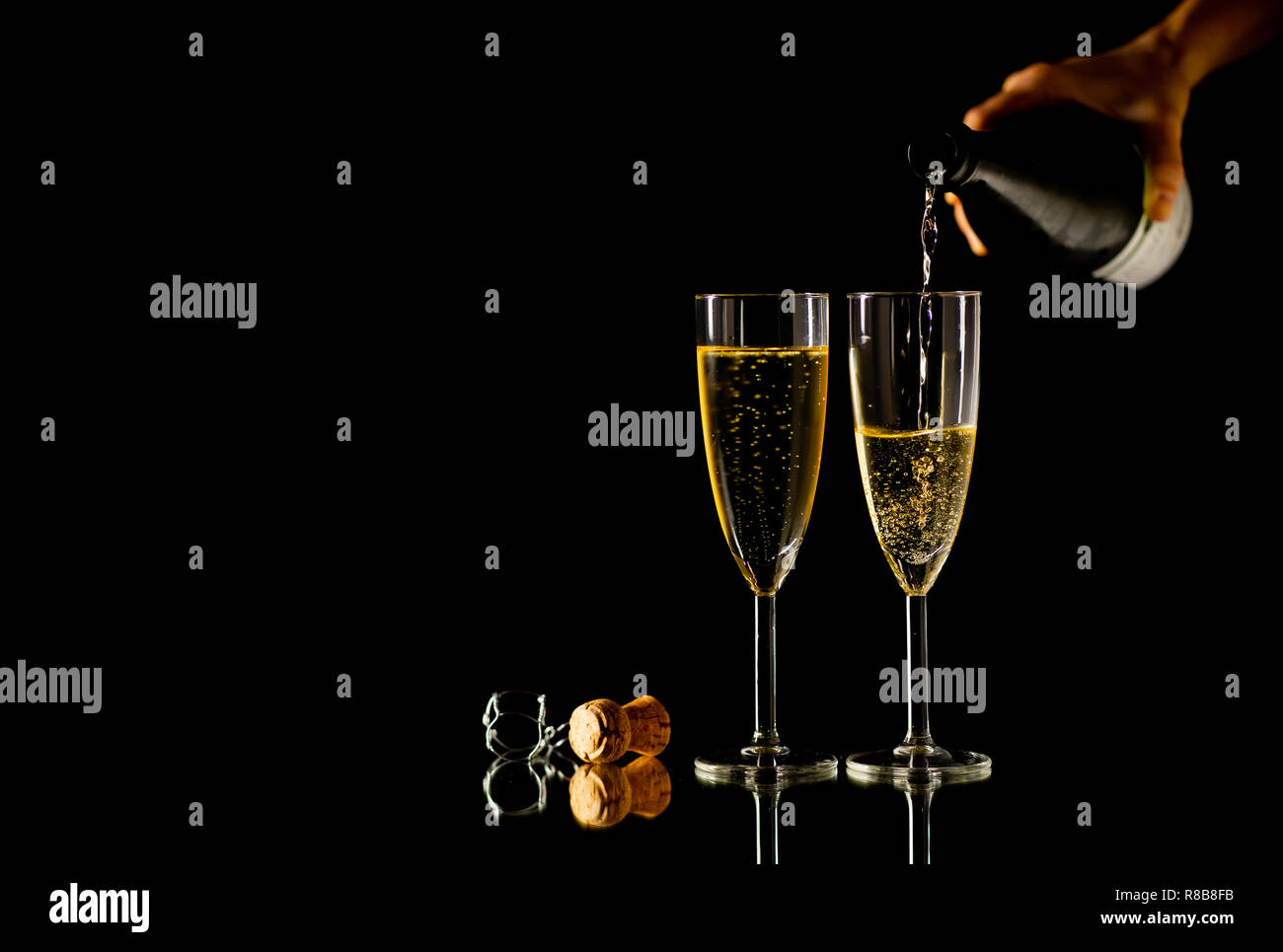 Zwei Gläser mit Champagner Ausgießen aus der Flasche bereit zu Toast in der Feier Konzept an Silvester Weihnachten Valentinstag und glückliche Zeiten isolieren Stockfoto