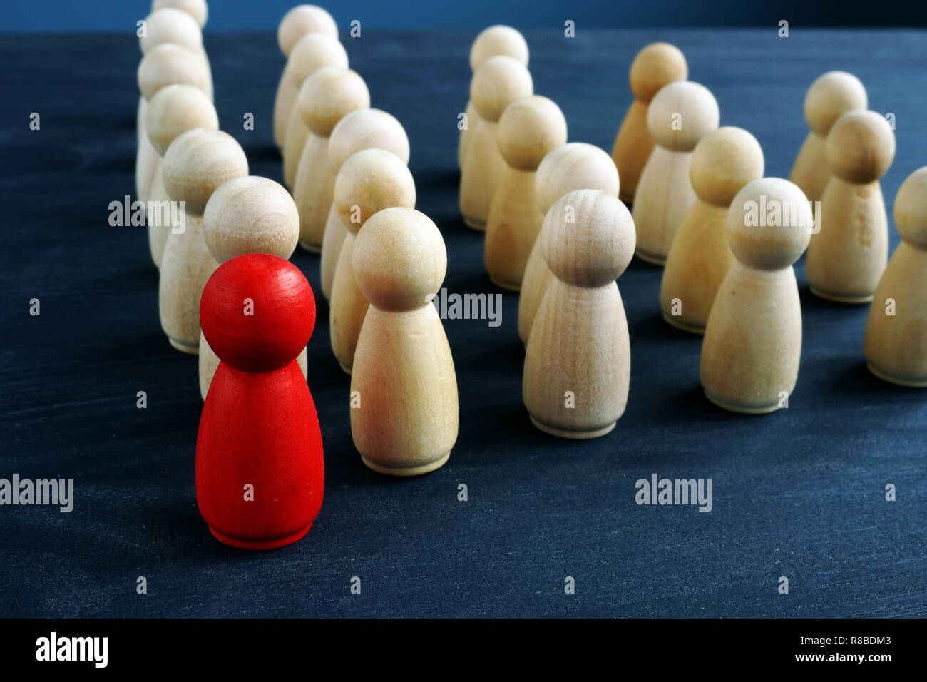 Leiter oder Manager vor Publikum. Figuren aus Holz auf einem Schreibtisch. Stockfoto