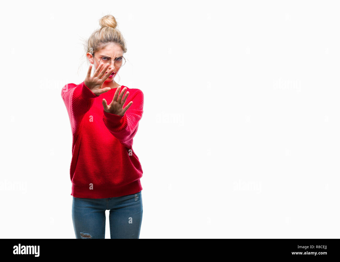 Junge hübsche blonde Frau das Tragen der roten Pullover und Gläser über isolierte Hintergrund Angst und Furcht Ausdruck stop Geste mit der Hand erschrocken Stockfoto