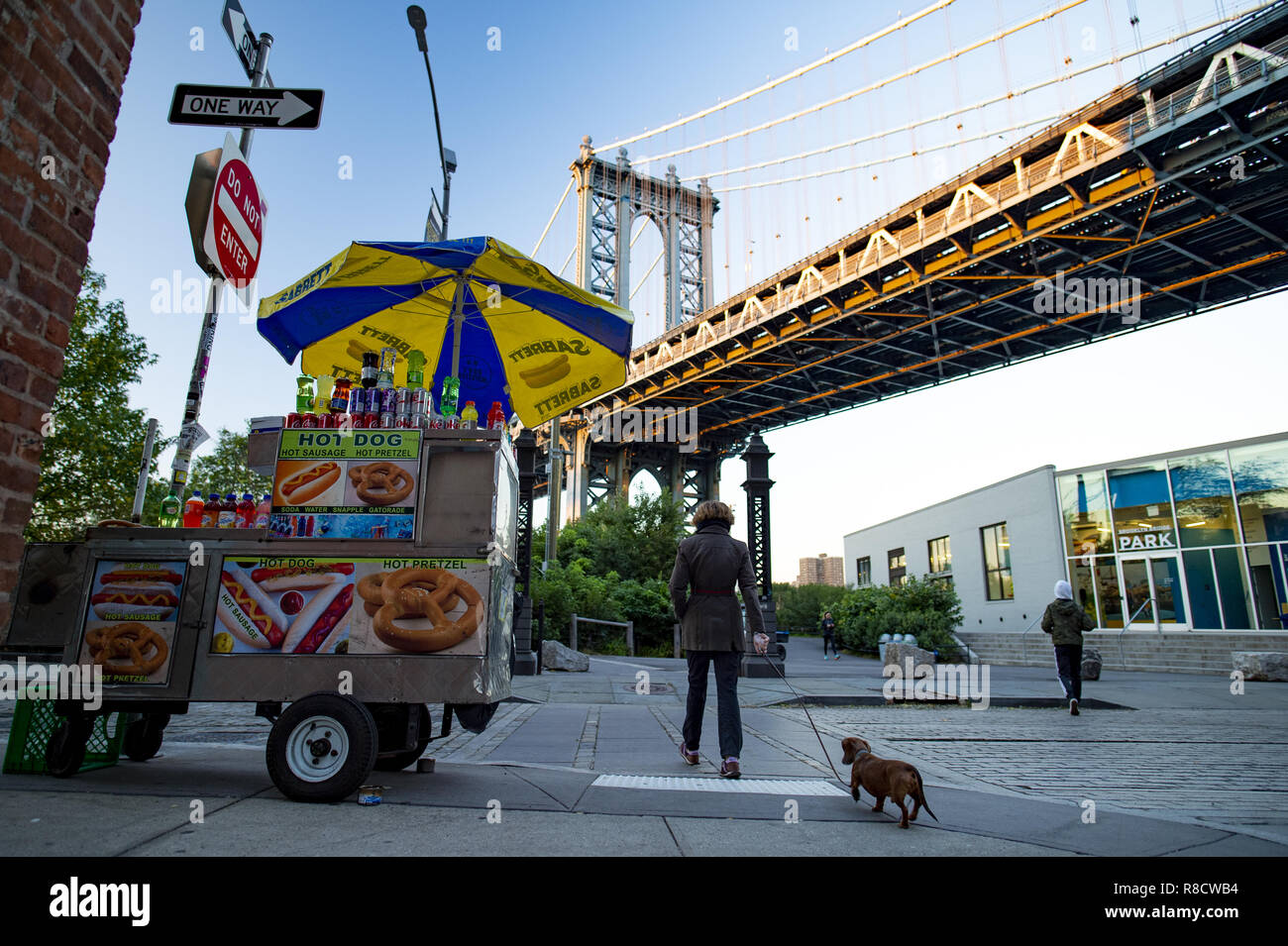 Ein Lebensmittel stehen unter der Manhattan Bridge geparkt, während eine Frau geht mit seinem Hund. Stockfoto