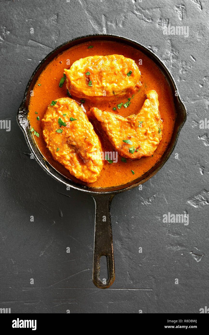 Fisch in der Pfanne auf schwarzem Stein Curry. Indische Küche. Ansicht von oben, flach Stockfoto