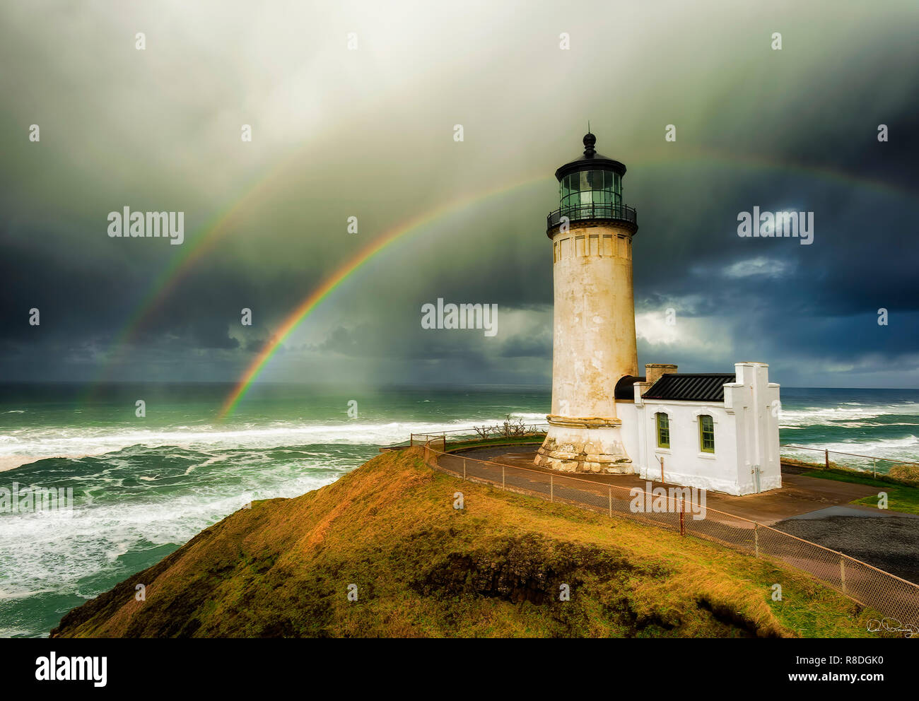 Einen doppelten Regenbogen Bögen über das Meer im Hintergrund dieser Ansicht von North Head Lighthouse auf der Washington Küste. Stockfoto