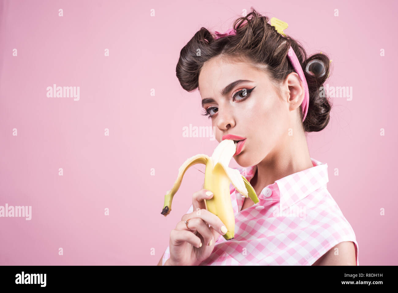 Bananen Diät. Pin up Frau mit trendigen Make-up. pinup Girl mit Mode Haare. retro Frau Banane essen. hübsches Mädchen im Vintage Style, kopieren. Verkauf von Gesundheit Stockfoto