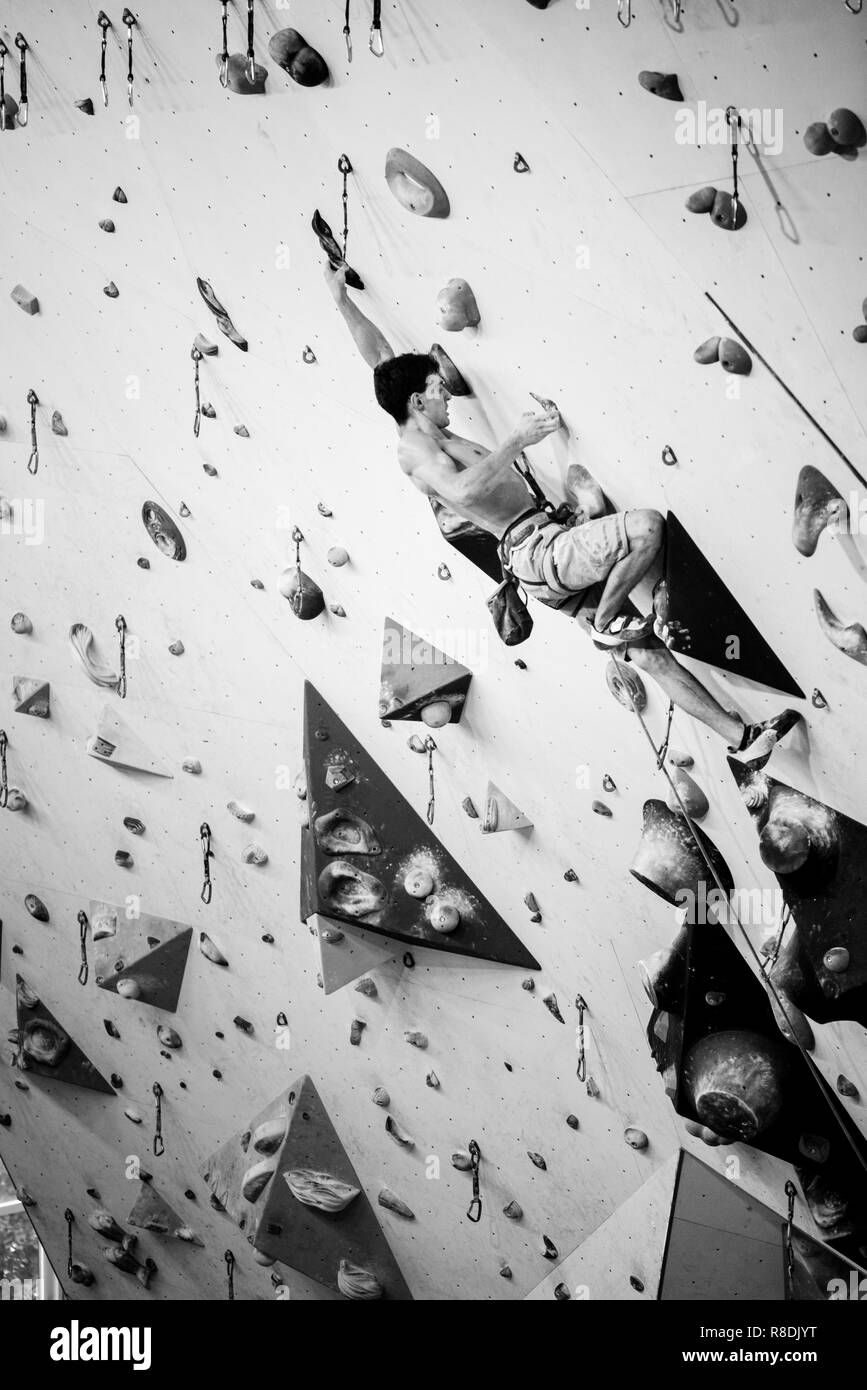 Kletterhalle. Sport Training. Athlet auf eine Kletterwand, Indoor Sports. Schwarz und Weiß Stockfoto