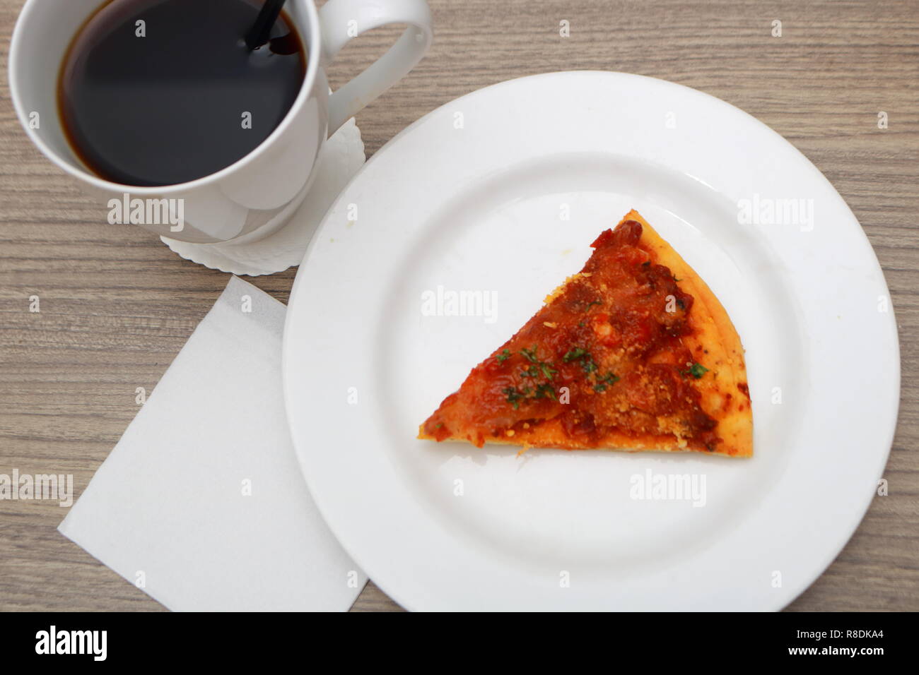 Ansicht von oben Stück Pizza und Tasse Kaffee am Morgen mit leerem Papier Vorlage Stockfoto