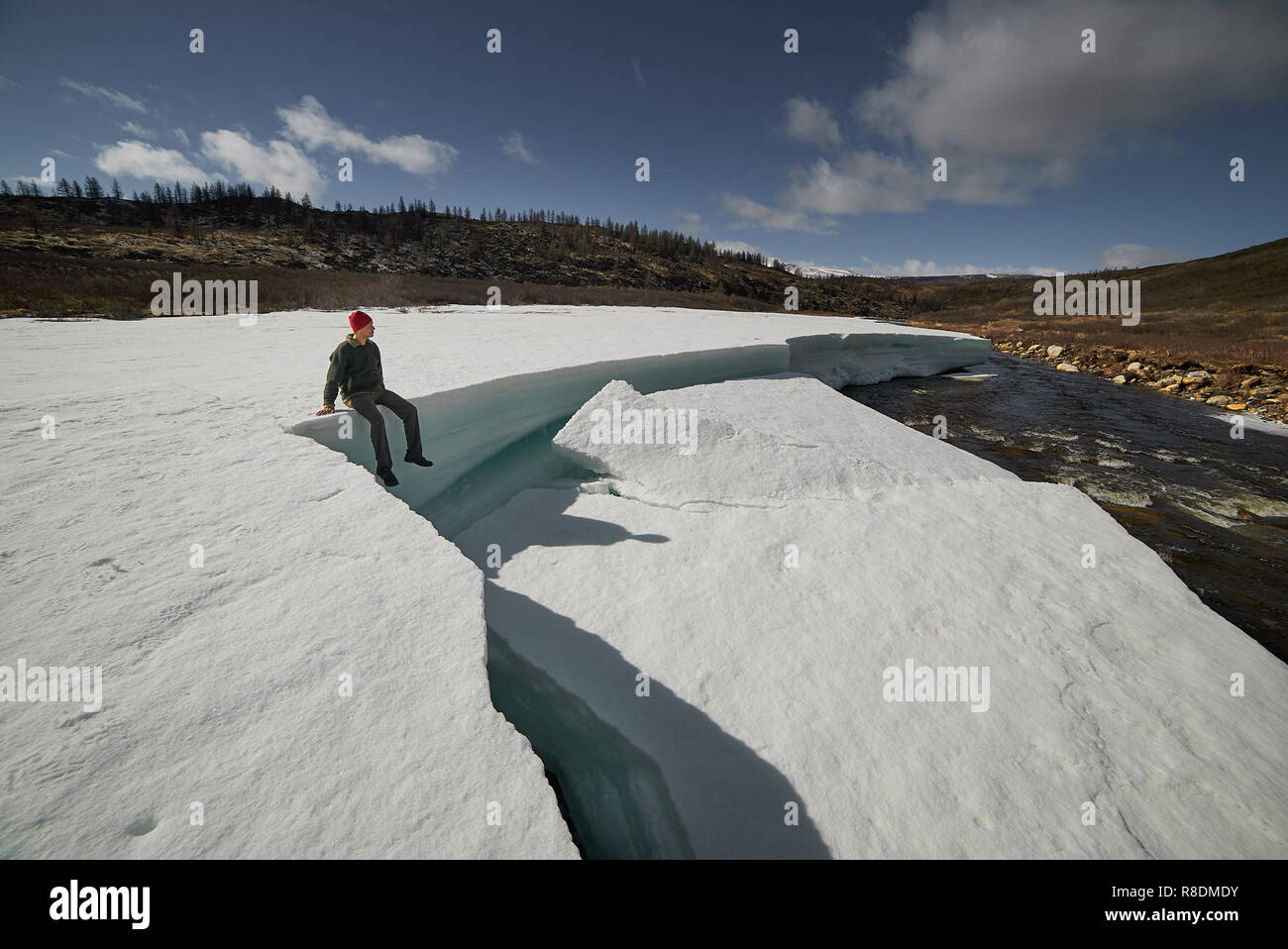 Mann reisender Sie exotische Wahrzeichen, im Big Ice Block sitzen. Stockfoto