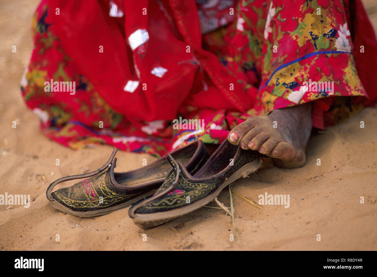 Ein Zigeuner indische Frau trägt einen roten Sari sitzt Barfuss im Sand  nach ihre Schuhe ausziehen, Wüste Thar, Pushkar, Rajasthan, Indien  Stockfotografie - Alamy