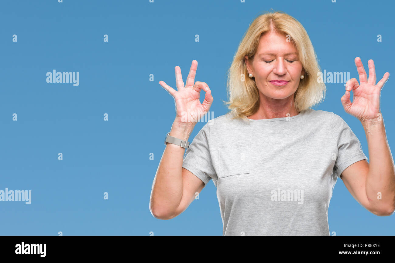 Blonde Frau mittleren Alters über isolierte Hintergrund entspannen und Lächeln mit den Augen dabei geschlossen Meditation Geste mit den Fingern. Yoga Konzept. Stockfoto