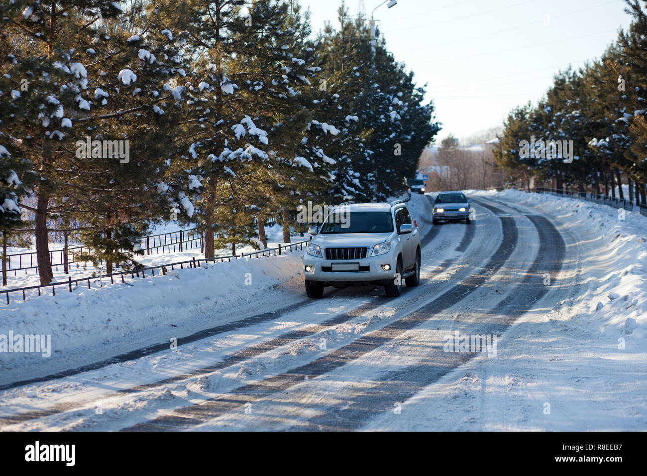 Autos auf ein Eis Stadt winter Straße mit Bäumen rund um Stockfoto