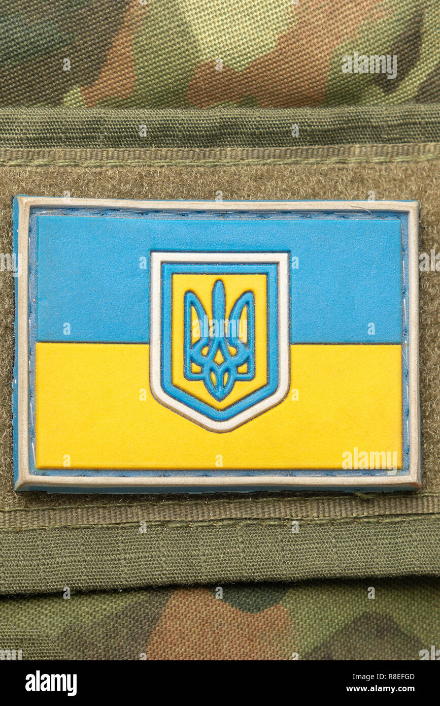 Ukrainische Flagge auf dem Hintergrund einer Camouflage Military Jacke und zur Bekämpfung der Kugeln. Land Verteidigung Konzept Stockfoto