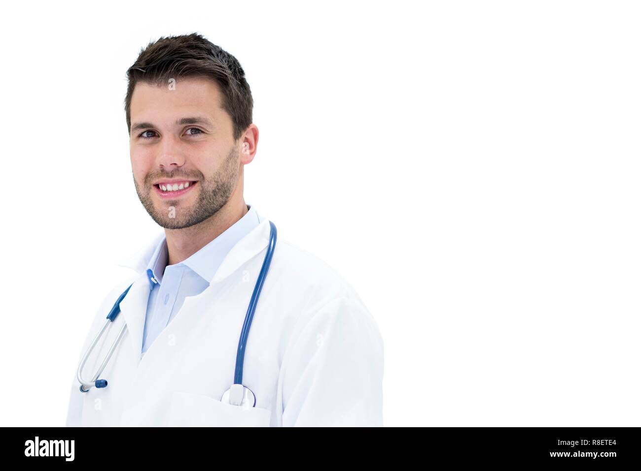 Junge männliche Arzt lächelnd in Richtung Kamera. Stockfoto