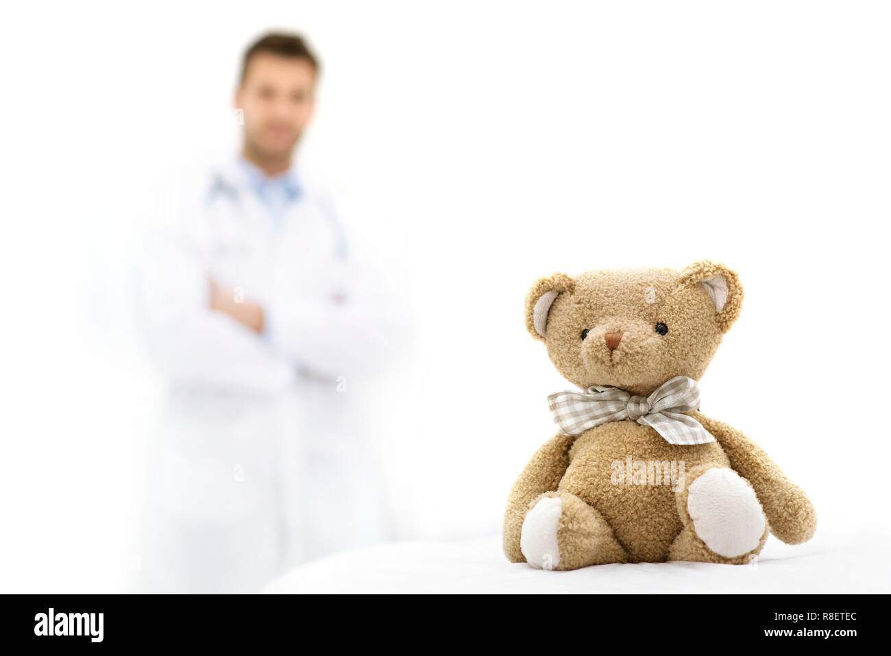 Teddybär mit männlicher Arzt im Hintergrund. Stockfoto