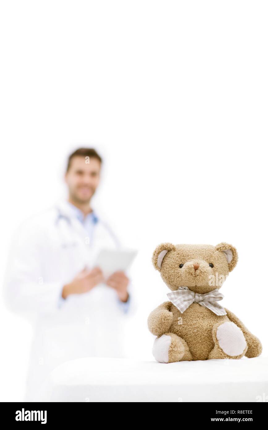 Teddybär mit männlicher Arzt im Hintergrund. Stockfoto
