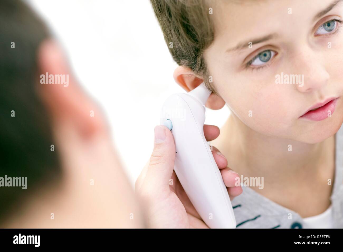 Junge in seiner Temperatur mit einem digitalen Thermometer genommen. Stockfoto