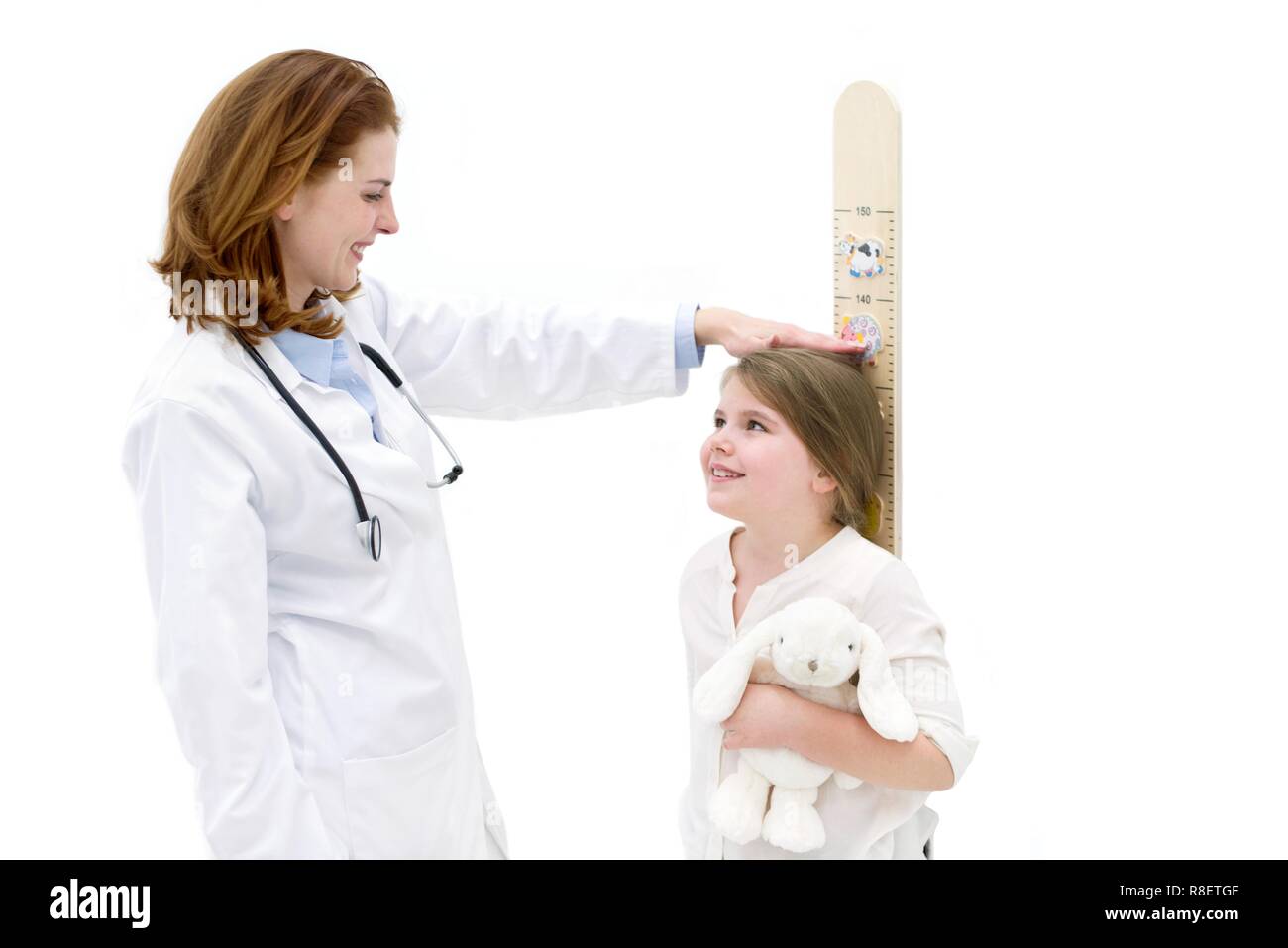 Ärztin messen junge Mädchen auf Höhe chart. Stockfoto