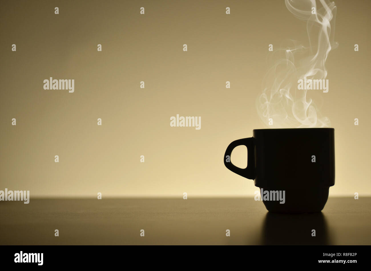 Silhouette heißen Kaffee Tasse mit Dampf in der Nähe der hellen beigen Hintergrund Stockfoto